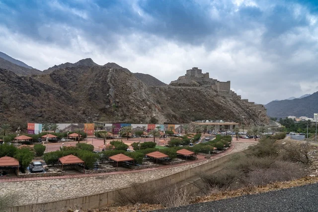 قلعة حجرية قديمة على جبل وعر مع منتزه