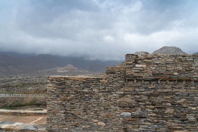 Traditional Stone Wall in Mountain Landscape with Clouds