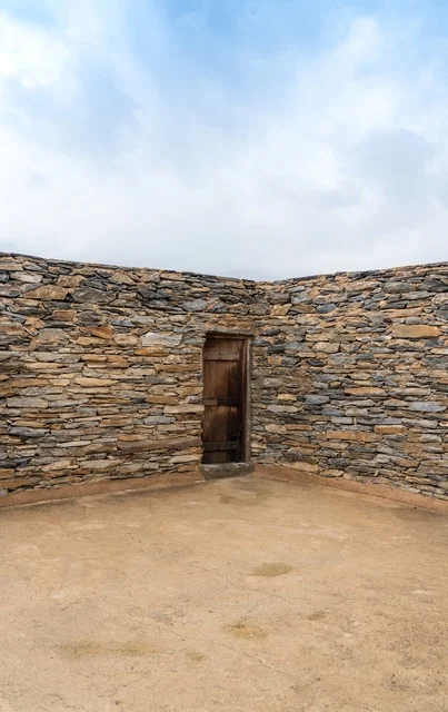 عمارة المنازل الحجرية التقليدية القديمة مع باب خشبي