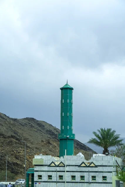 مسجد بمئذنة خضراء وسط الجبال في السعودية