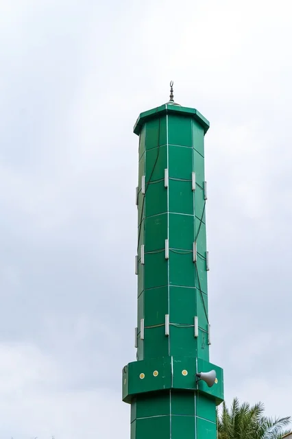 Green Mosque Minaret with Loudspeaker and Cloudy Sky