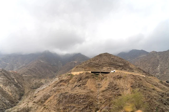جبال صخرية وعرة مع ضباب وجسر طرق
