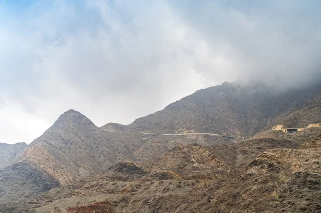 منظر الجبال الصخرية تحت سماء غائمة وضبابية