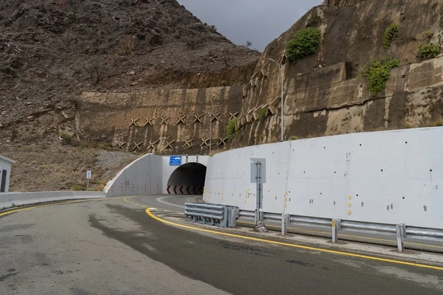 نفق جبلي وطريق أسفلتي مع بنية تحتية خرسانية صلبة حديثة