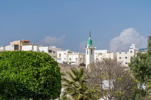 Urban Buildings and Mosque Minaret under Blue Sky