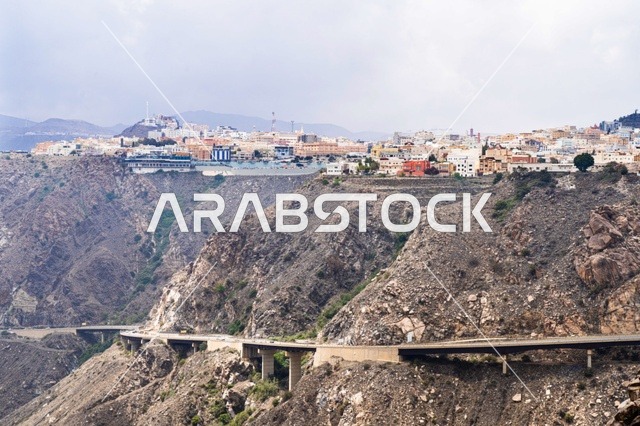 مدينة جبلية مع جسر منحدر وتضاريس صخرية