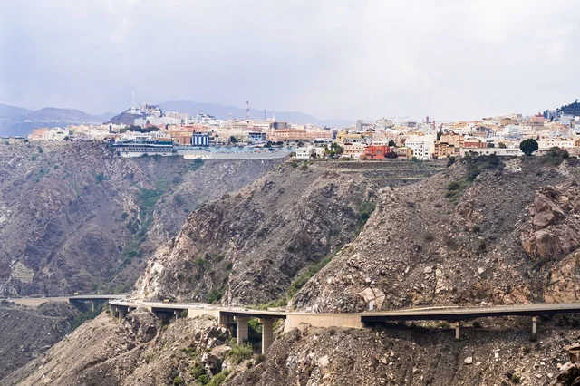 Mountain City with Cliffside Bridge and Rocky Terrain