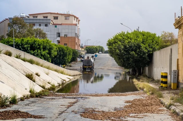 Flooded Urban Street with Water Tanker Truck After Rain