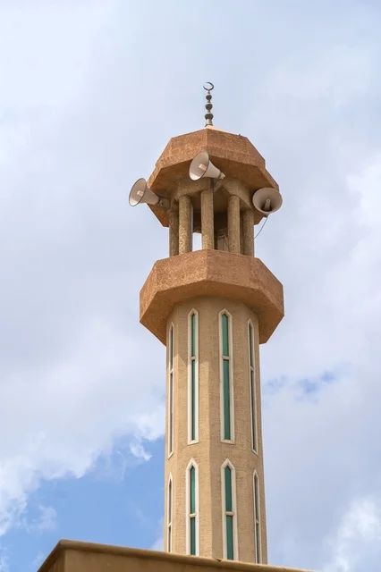Mosque Minaret with Loudspeakers Against Cloudy Sky