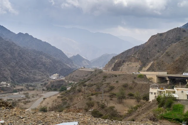 Mountain Road Through Rocky Valley Under Cloudy Sky