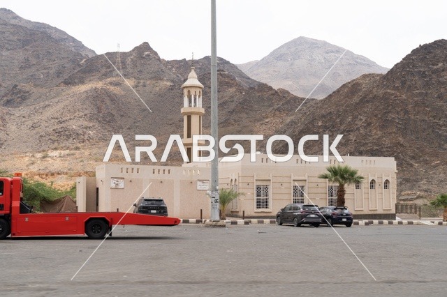 مسجد صغير عند سفح الجبل مع موقف سيارات