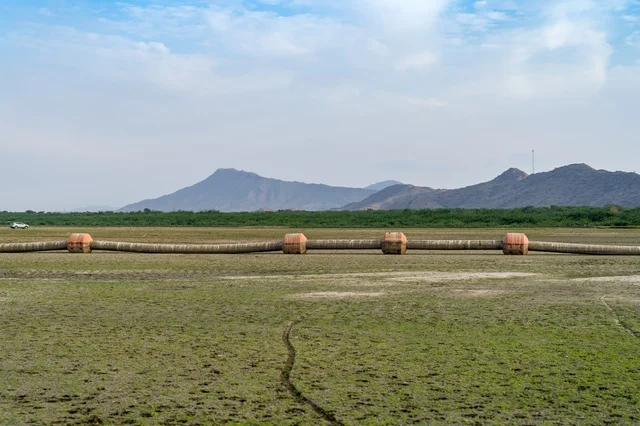 Industrial Pipeline in Green Field with Mountains