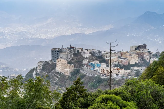 Mountain Village Buildings and Green Landscape in Mist