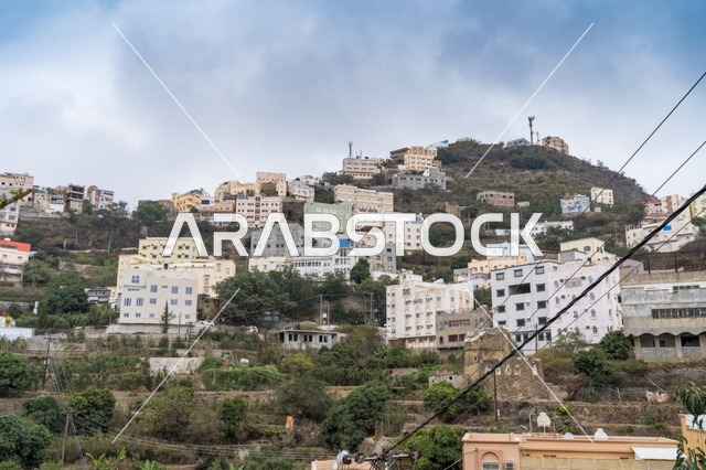 مباني سكنية على سفح الجبل تحت غيوم