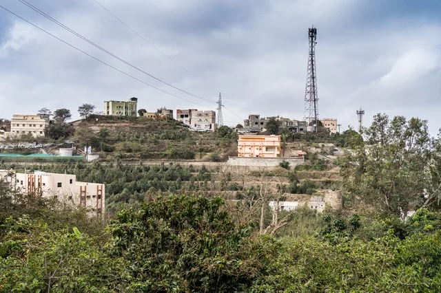 Residential Buildings and Telecom Towers on a Green Hillside