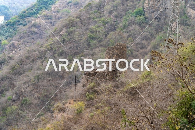 برج حجري قديم على الجبل مع خطوط كهرباء