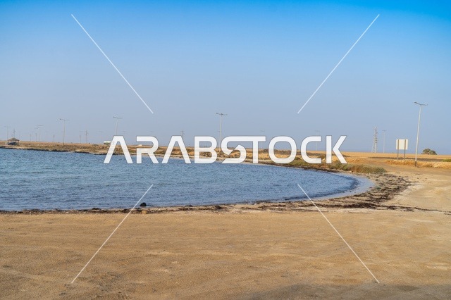 ساحل الخليج والشاطئ الرملي تحت السماء الزرقاء الصافية