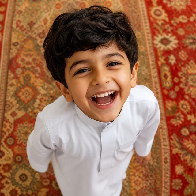 Saudi Boy in Traditional Thobe Laughing at Camera