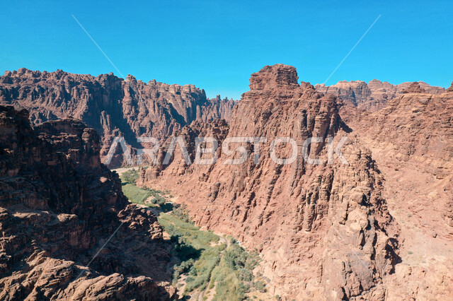 An aesthetic picture of the charming mountain canyons, rock formations and oases in Wadi Al-Disah in the Tabuk region, Wadi Al-Disah (the valley filled with palms) the charming nature and its scenic beauty in the Kingdom of Saudi Arabia