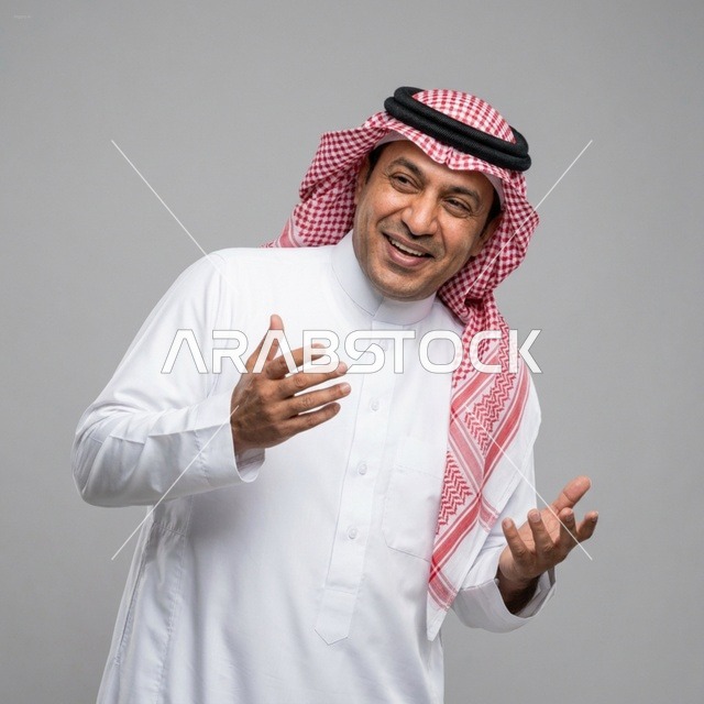 رجل سعودي مبتسم يرتدي الزي التقليدي يشير بيديه للتواصل