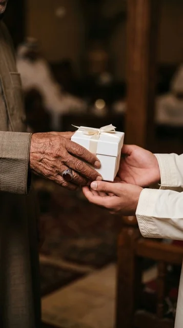 Close-up of Elderly Hand Giving Charity Gift Box