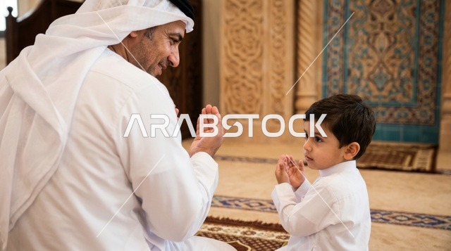 رجل وطفل يؤديان الصلاة في المسجد الكبير بالكويت