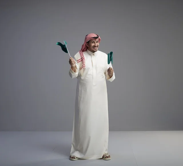 Saudi Man Holding Flags for National Day Celebration
