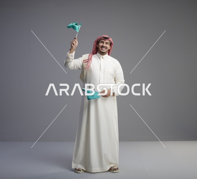 رجل سعودي يحمل الأعلام الوطنية في الاستوديو