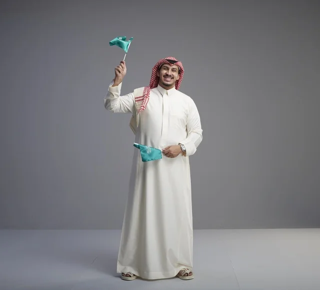 رجل سعودي يحمل الأعلام الوطنية في الاستوديو