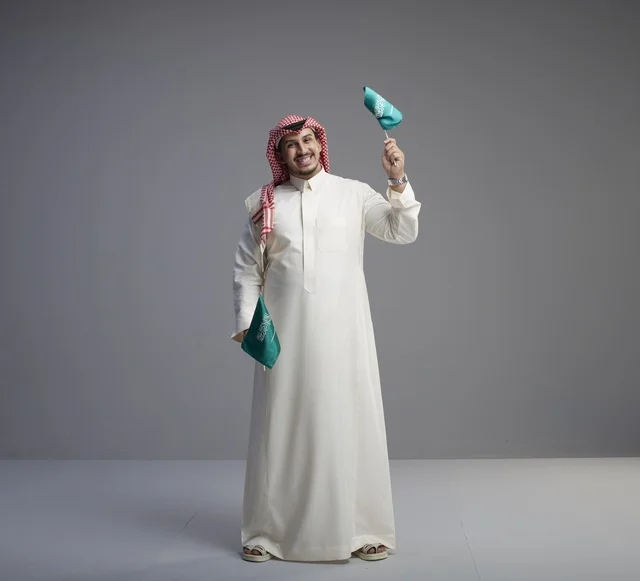 Saudi Man Holding National Flags in Professional Studio