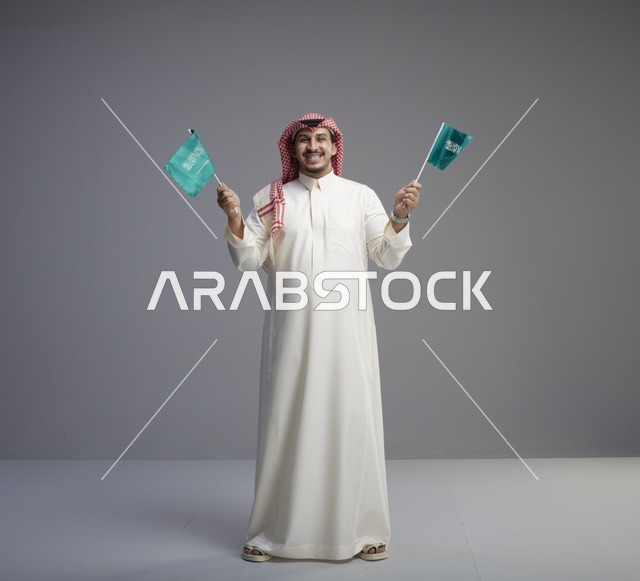 رجل سعودي يحمل العلم السعودي في الاستوديو