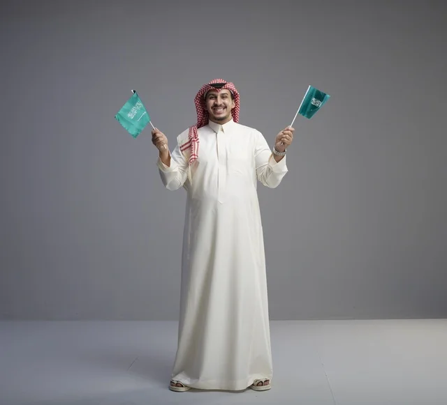 رجل سعودي يحمل العلم السعودي في الاستوديو