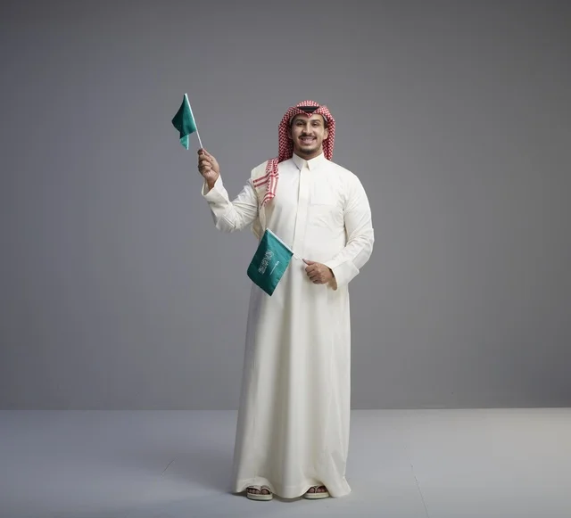 Saudi Man Holding National Flags in Studio Setting