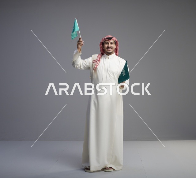 رجل سعودي يحمل أعلام المملكة العربية السعودية