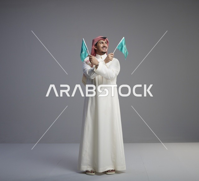 رجل سعودي يحمل علم السعودية في الاستوديو