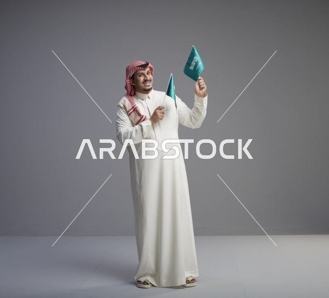 رجل سعودي يحمل العلم السعودي في الاستوديو