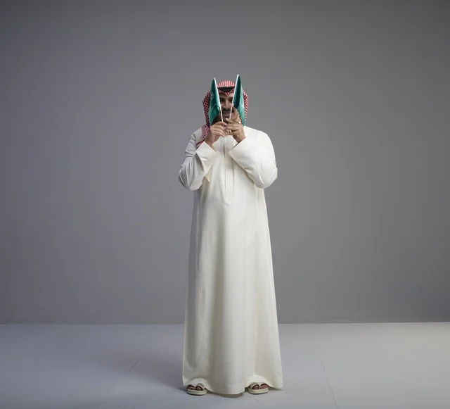 رجل سعودي يحمل علم المملكة في الاستوديو