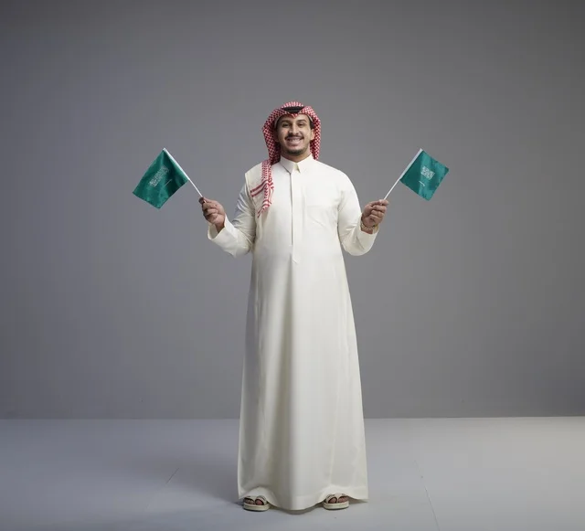 Saudi Man Holding Saudi Arabia Flags in Studio