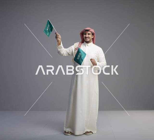 رجل سعودي يحمل الأعلام السعودية في الاستوديو