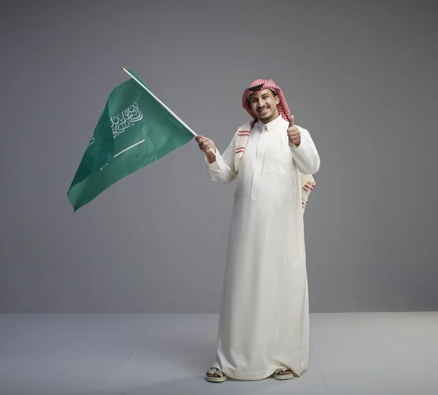 Saudi Man with National Flag Giving Thumbs Up