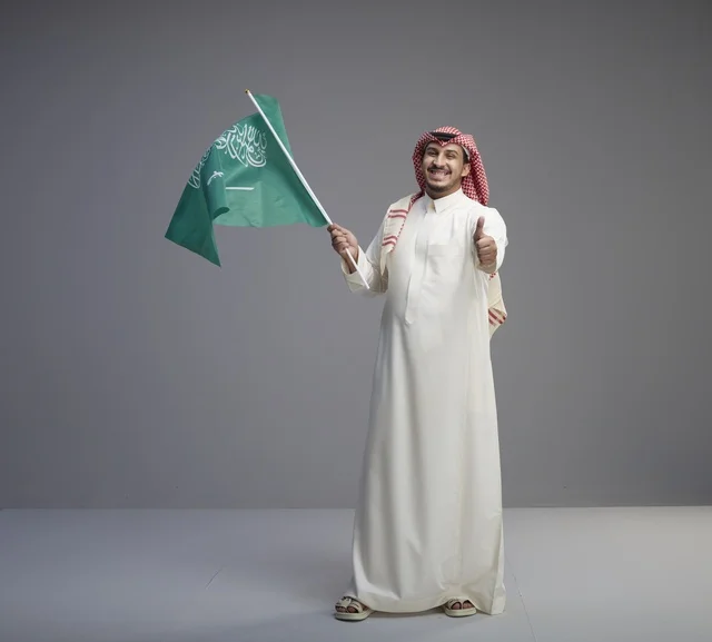 Saudi Man Holding National Flag with Thumbs Up Gesture