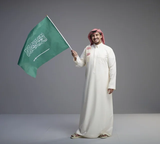 رجل سعودي يحمل العلم السعودي في الاستوديو