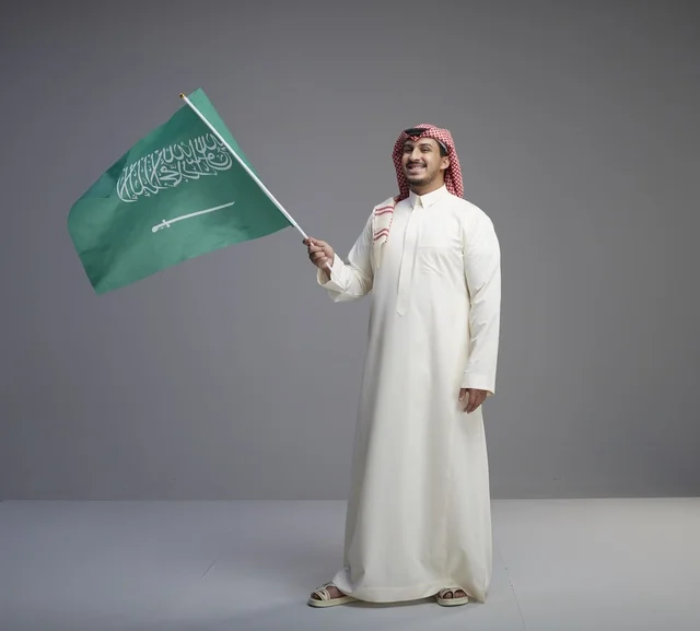 Saudi Man Waving National Flag in Traditional Thobe