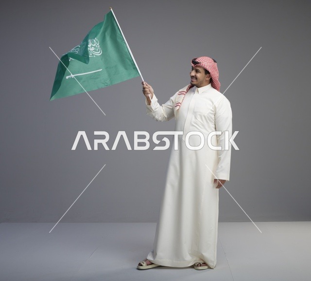 رجل سعودي يرفع علم المملكة العربية السعودية