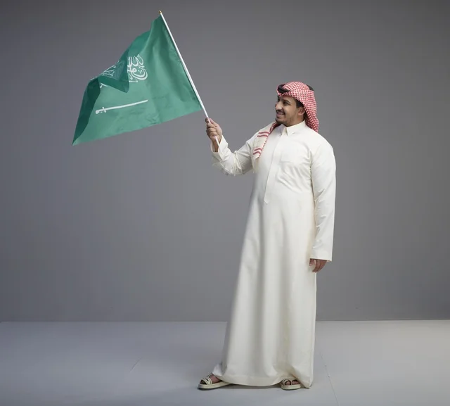 رجل سعودي يرفع علم المملكة العربية السعودية