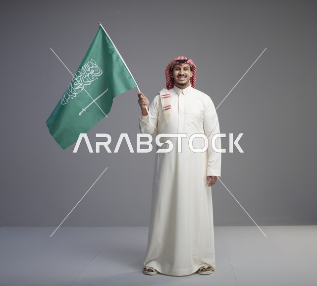 رجل سعودي يحمل علم المملكة العربية السعودية