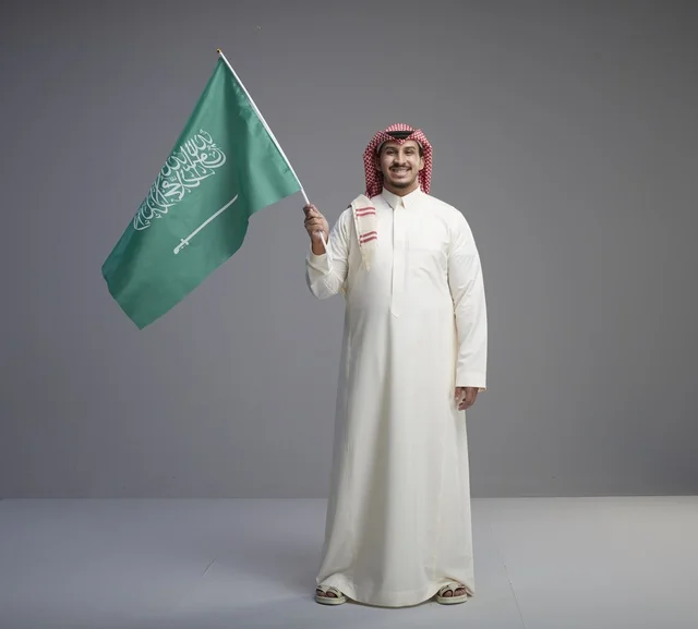 Saudi Man Holding Saudi Arabian Flag in Studio