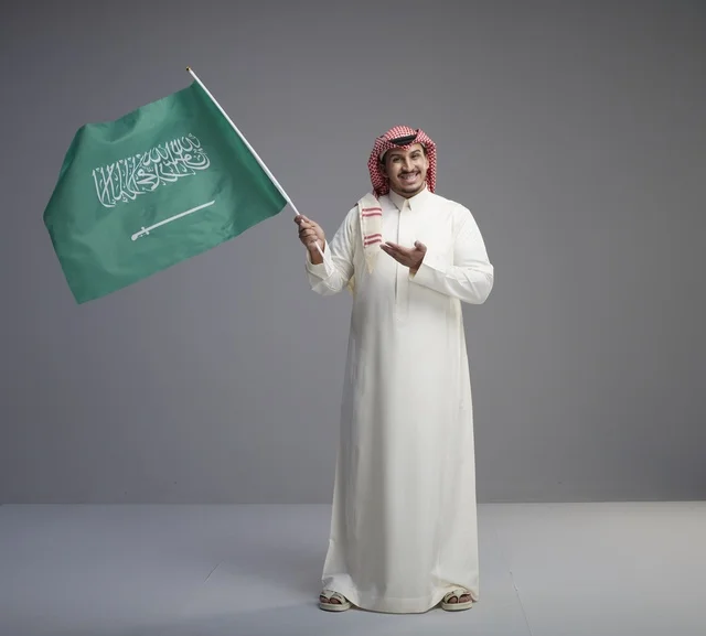 Saudi Man Holding Saudi National Flag in Studio Portrait