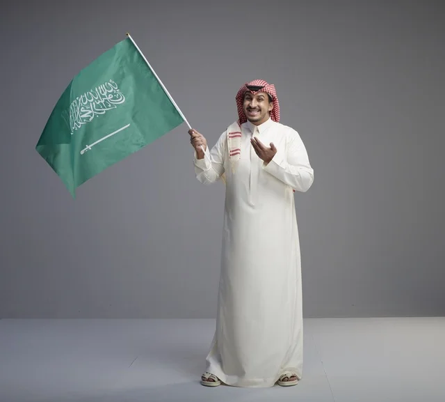 رجل سعودي يحمل علم المملكة العربية السعودية