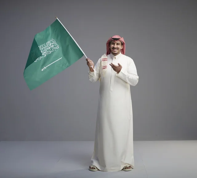 رجل سعودي يحمل العلم الوطني في الاستوديو